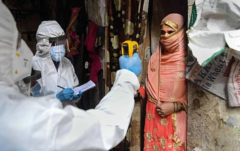 Health workers wearing PPE kits carry out a medical checkup of residents of Dharavi slum area in Mumbai Thursday July 9 2020. (Photo | PTI)