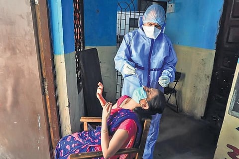 A health worker collects sample from a person for Covid-19 test in Thane | pti