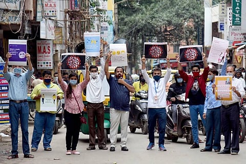 Citizens raise awareness on free COVID testing by BBMP at Chikpete area in Bengaluru on Sunday. (Photo | Nagaraja Gadekal/EPS)