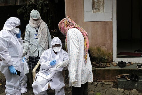 A health worker waits to take nasal swab samples to test for COVID-19 at a medical camp in Mumbai, India, Saturday, Aug. 8, 2020. (Photo | AP)