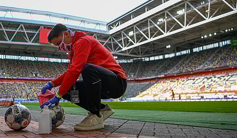 Footballs are disinfected during a Bundesliga match. (Photo | AP)