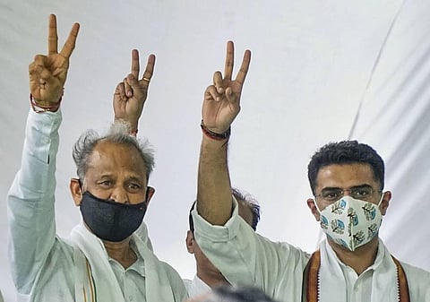 Rajasthan CM Ashok Gehlot along with senior Congress leader Sachin Pilot flashes victory signs during the party MLAs meeting at CM residence in Jaipur on Thursday. (Photo | PTI)