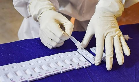 A medic wearing a PPE conducts COVID-19 rapid antigen testing in Kolkata. (Photo | PTI)