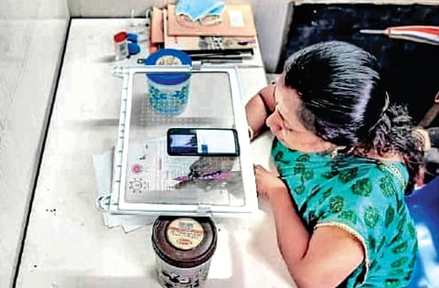 The photo of a teacher using a refrigerator tray as a mobile phone stand during an online class has gone viral on social media