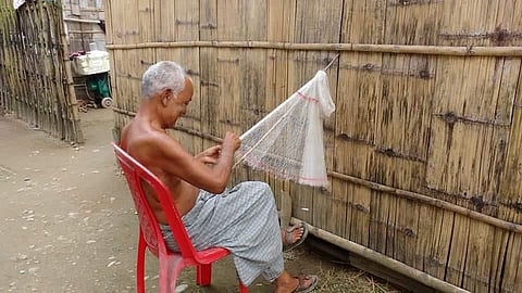 Lakshmi Kanta Roy weaving a fishing net in front of his house (Photo | EPS)