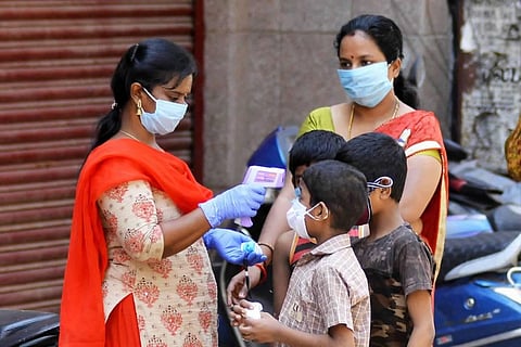 A healthcare worker checks temperature of kids at a fever camp organized by the Chennai Corporation (Photo | Debadatta Mullick/EPS)