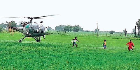 An Indian Air Force helicopter lands in a field after airlifting farmers from flooded areas, at Tekumatla mandal in Jayashankar Bhupalpally district on Saturday