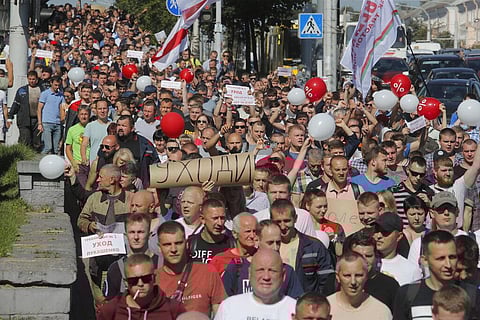 Workers with handmade posters reading 'Go away!' march toward the Minsk Wheel Tractor Plant where Belarusian President Alexander Lukashenko addresses employees in Minsk, Belarus, Monday. (Photo | AP)