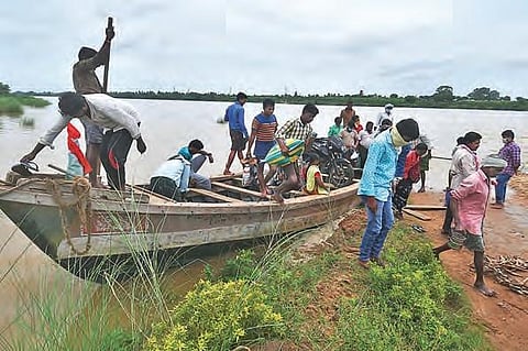 As the road leading to Pamula Lanka is submerged in water, villagers use a mechanised boat to go to the other side of a flooded stream near Vijayawada. (Photo | Prasant Madugula, EPS)