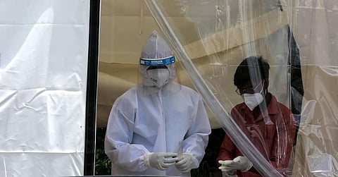 A health worker in PPE coveralls befor collection swab samples for Covid-19 rapid antigen testing. (Photo | Shekhar Yadav, EPS)