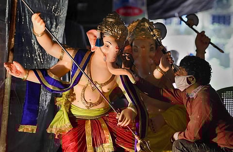 An artist works on an idol of Lord Ganesha slaying a structure resembling coronavirus with a trident ahead of the upcoming Ganesh Chaturthi festival at Lower Parel in Mumbai. (Photo | PTI)