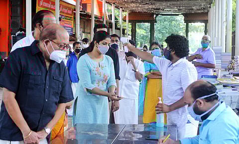 Ernakulam Siva Temple employees thermal scan devotees and enter their details in the register on the auspicious day of Chingam 1. (Photo | A Sanesh, EPS)