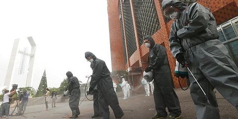 Public officials disinfect the roadway to help curb the spread of the coronavirus in front of the Yoido Full Gospel Church in Seoul, South Korea. (Photo | AP)