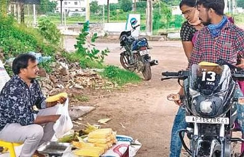 Pagidipalli Ramesh, a former college lecturer, sells cobs on the roadside in Madhira town on Saturday. (Photo| EPS)
