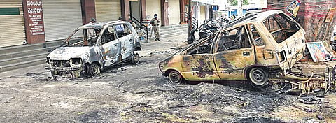 Charred vehicles lie by a roadside in DJ Halli following the violence | VINOD KUMAR T