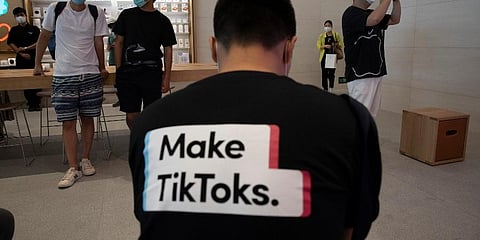 A man wearing a shirt promoting TikTok is seen at an Apple store in Beijing on Friday, July 17, 2020. (Photo | AP)