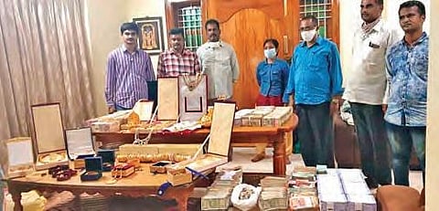Officials with the cash and gold ornaments seized during the raid I Express