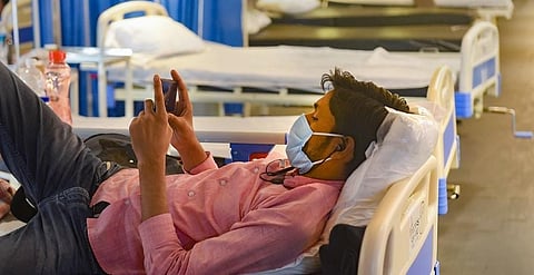 A COVID-19 patient using mobile phone inside an isolation ward. (Photo | PTI)