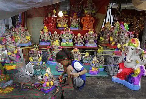 A girl gives finishing touch to an idol of elephant-headed Hindu god Ganesha ahead of Ganesh Chaturthi festival in Ahmedabad, India, Friday, Aug. 21, 2020. (Photo | AP)