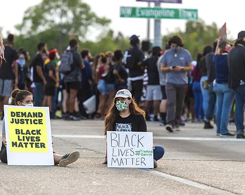 Protesters take to the street and block traffic at the intersection of Willow Street and Evangeline Thruway after a vigil held Saturday (Photo | AP)