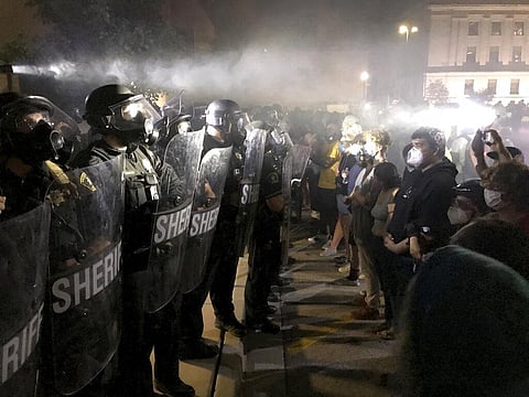 Protestors confront Kenosha County Sheriff's Deputies outside the Kenosha Police Department in Kenosha, Wis., on Sunday, Aug. 23, 2020. (Photo | AP)