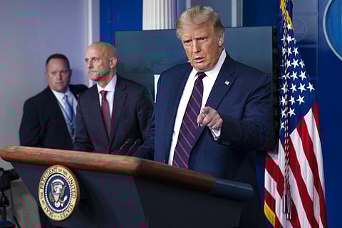 President Donald Trump speaks, accompanied by Food and Drug Administration Commissioner Dr. Stephen Hahn, center, during a media briefing. (Photo | AP)