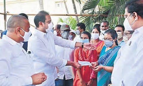 Deputy Chief Minister (Health) Alla Kali Krishna Srinivas hands over cheques for `50 lakh to the kin of hotel fire victims in Vijayawada on Tuesday (Photo | EPS)