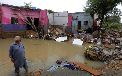 Local residents examine their damaged house caused by heavy monsoon rains, in Yar Mohammad village near Karachi. (Photo | AP)