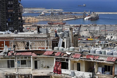 Workers repair water tanks and damaged apartments overlooking the site of the Aug. 4 explosion that hit the seaport, in Beirut (Photo | AP)