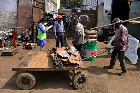 A corporation employee, on door-to-door survey, asking people of covid-19 symptoms at an auto-scrapyard at Pudupet in Chennai on Saturday. (Photo | EPS)
