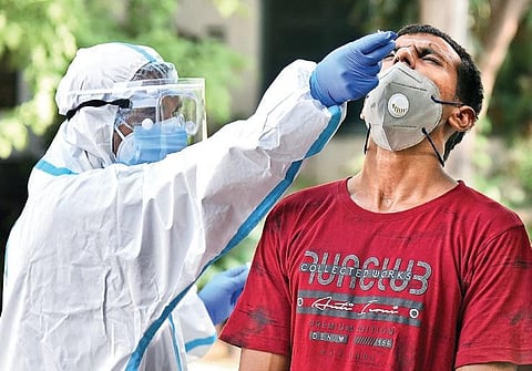A health worker collects a sample for coronavirus testing at Darya Ganj. (Photo | EPS/Parveen Negi)