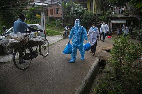 A health worker walks during a door-to-door drive to take nasal swab samples to test for COVID-19 in Gauhati, India, Saturday, Aug. 29, 2020. (Photo | AP)