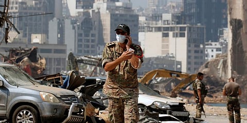 A Lebanese soldier uses his phone at the damaged site of the massive blast in Beirut's port area, in Beirut. (Photo | AP)