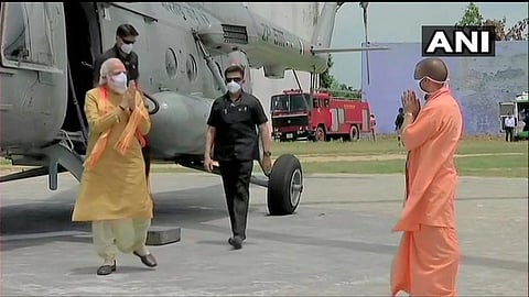 Wearing traditional dhoti-kurta, PM Modi deboarded an Air Force helicopter which flew him and was welcomed at the Saket helipad by Chief Minister Yogi Adityanath (Photo | ANI)