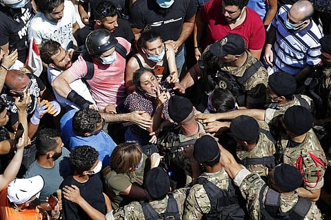A woman yells at Lebanese soldiers during scuffles with the soldiers who are blocking a road as French President Emmanuel Macron visits the Gemmayzeh neighborhood, Beirut. (Photo | AP)