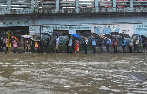 Pedestrians cross a waterlogged street during heavy rains at at Byculla area in Mumbai Wednesday Aug. 5 2020. (Photo | PTI)