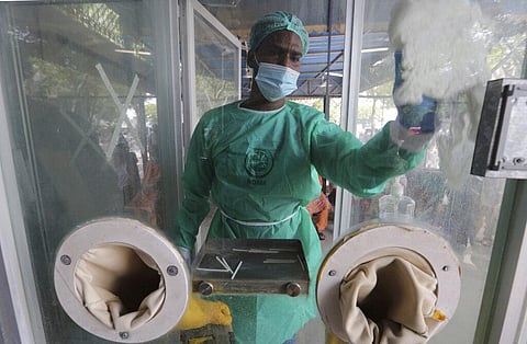 An employee cleans a booth at a testing and screening facility for the new coronavirus, in a hospital in Karachi, Pakistan, Friday, July 17, 2020. (Photo | AP)
