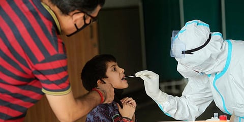 A health worker collects a swab sample to test for COVID-19 at a government hospital in Jammu. (Photo | AP)