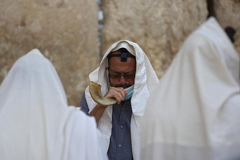 An ultra-Orthodox Jewish man blows a shofar, a musical instrument made from an animal horn, as he prays ahead of the Jewish new year at the Western Wall in Jerusalem's old city. (Photo | AP)