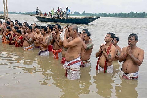 Devotees perform 'Tarpan' ritual on the bank of Ganga river on the occasion of Mahalaya in Murshidabad district Thursday Sept. 17 2020. (Photo | PTI)