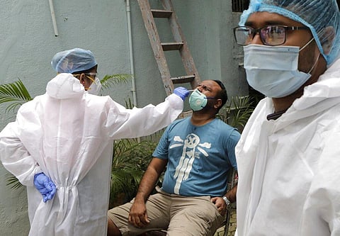 A health worker takes swab sample to test for COVID-19 outside a residential building in Mumbai, India, Sunday, Sept. 13, 2020. (Photo | AP)