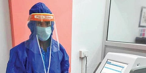 Phlebotomists at DIVOC Laboratories conduct tests in full PPE gear