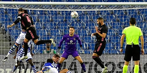 Real Madrid's Sergio Ramos jumps for the ball with Karim Benzema nearby as he tries to beat Real Sociedad's goalkeeper Alex Remiro during Spanish La Liga. (Photo | AP)