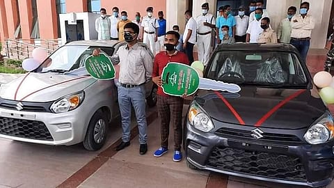 Manish Kumar Katiyar and Amit Kumar, who topped in class 10 and 12 this year, stand next to their cars (Photo | EPS)
