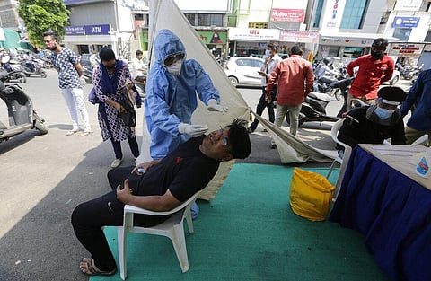 A health worker takes a nasal swab sample to test for COVID-19 test at a facility erected to screen people in Ahmedabad, India, Tuesday, Sept. 22, 2020. (Photo | AP)