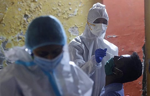 A Health worker collects a swab sample to test for COVID-19 in Mumbai. (Photo | AP)