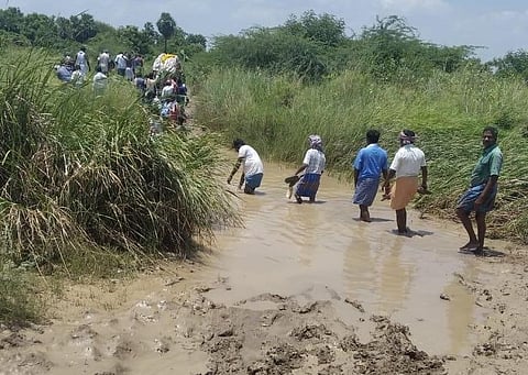 Funeral procession crossing knee-deep water in the Marakurichi village. (Photo | Express)