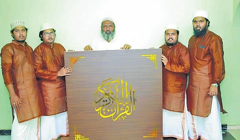 Noushad and his sons with the box in which the collar cloth rolls of handwritten Quran are fixed on a rotator | Express