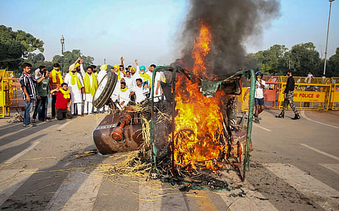 Farmers set on fire a tractor near India Gate during a protest against the new farm laws. (Photo | PTI)
