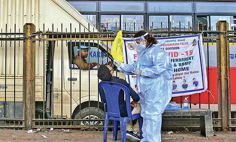 A health worker collects samples for Covid testing in Bengaluru on Sunday. (Photo | Shriram BN/EPS)